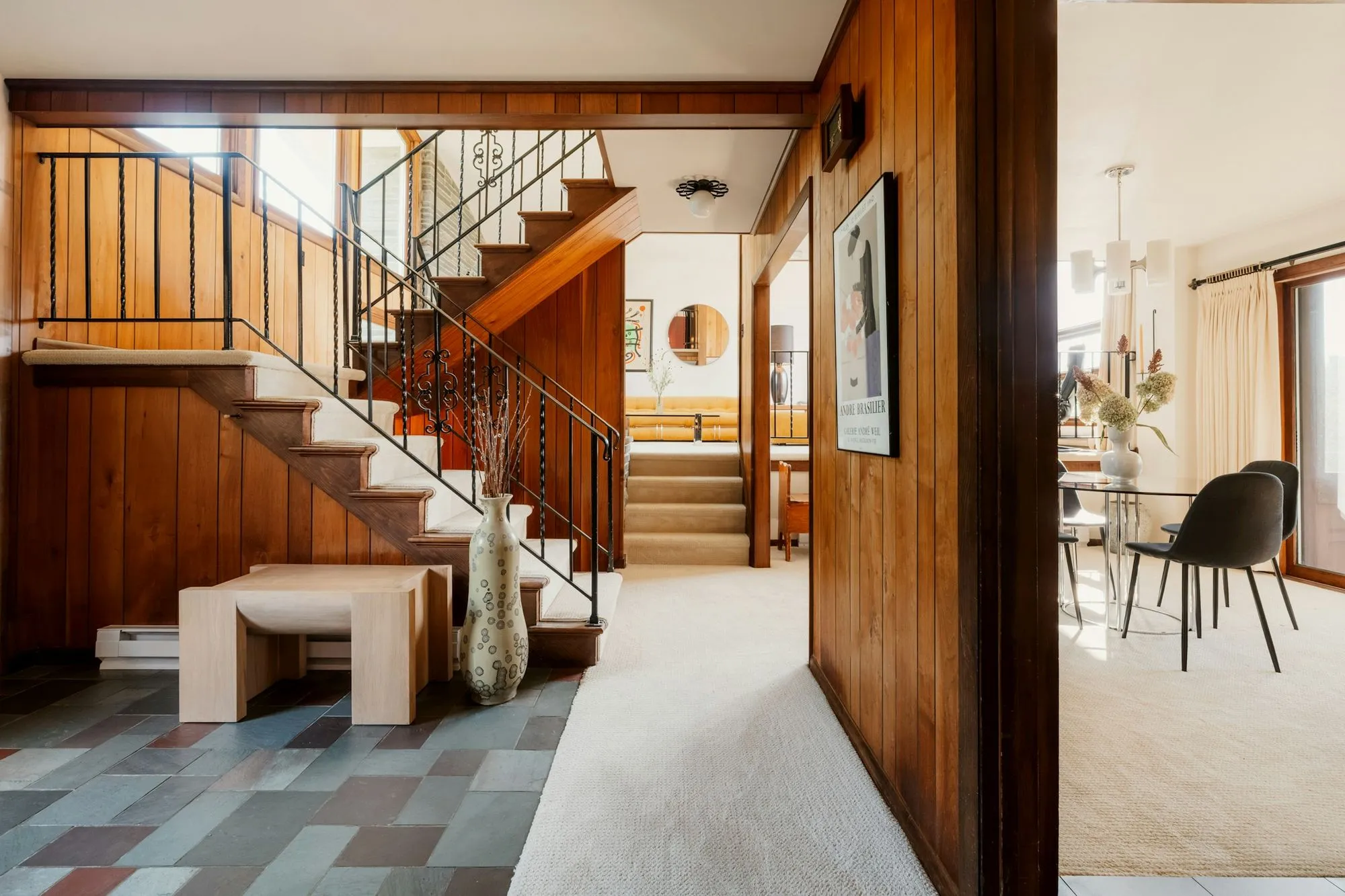 Half-level stair rising from a slate entry to a carpeted living room